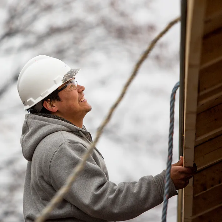 Man in hard hat looking at wooden roof