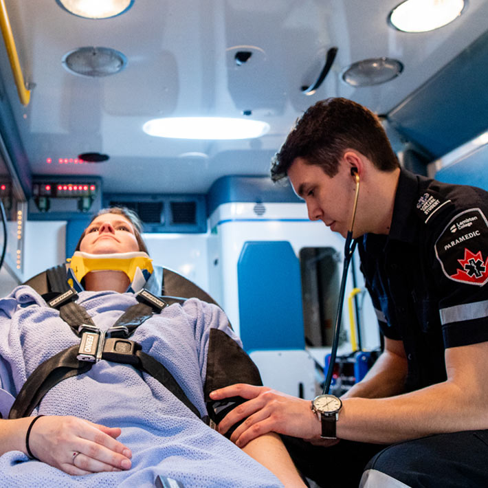 A paramedic student works on patient in back of ambulance