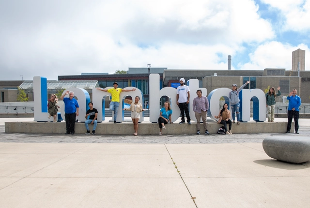 A group of student posing for a photo with the Sarnia Lambton College Welcome Back Sign Installation.