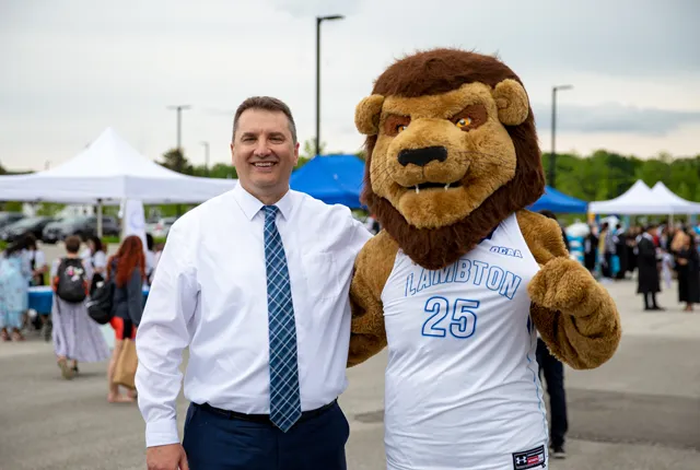 Rob Kardas posing with Lambton College's mascot, Pounce.