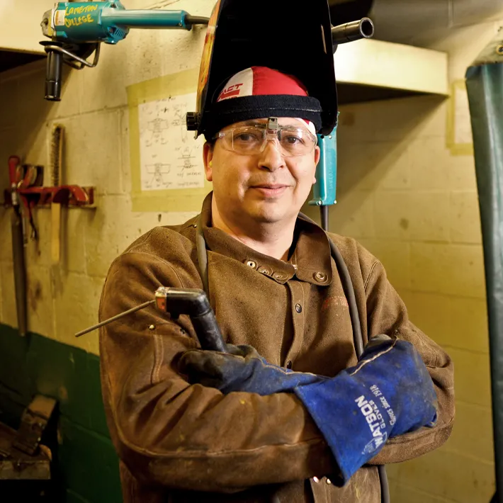 A photo of a student boilermaker posing for photo in workshop.