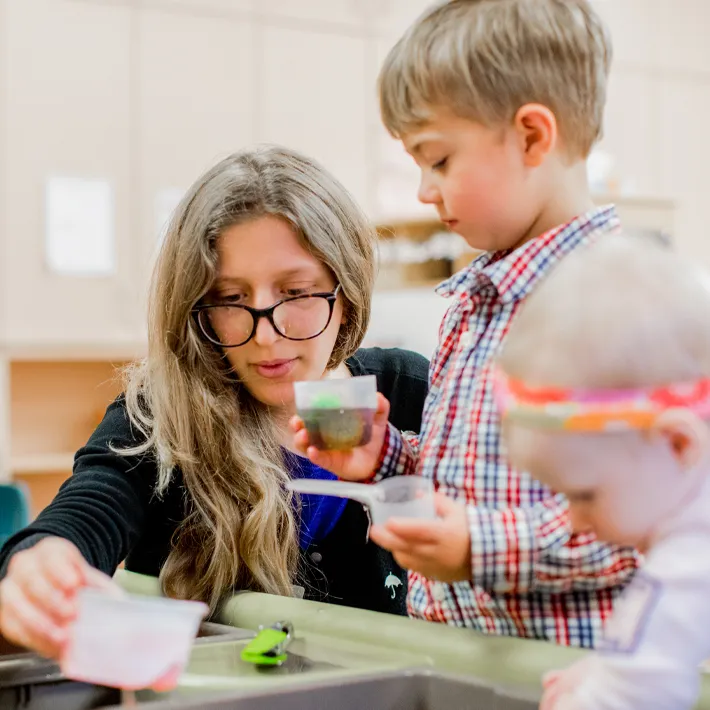 An EarlyON student showing kids how to play.