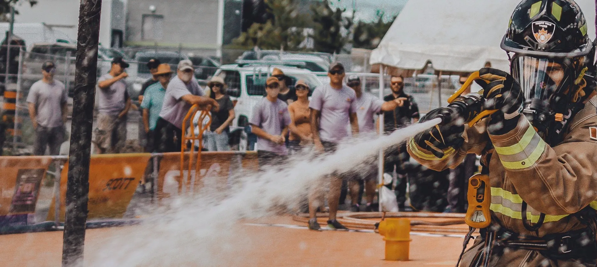 Firefighter spraying a water hose in a FireFit competition