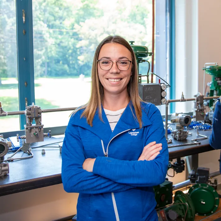 A student in the ICET lab posing for photo near work counter and window.