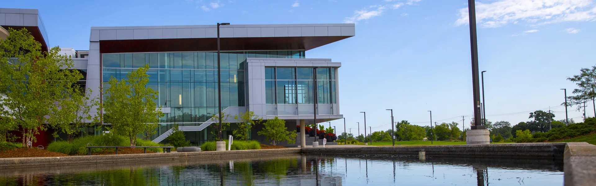 A photo of a campus building and pond.