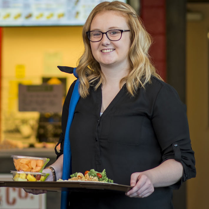 Student holding a tray of food.