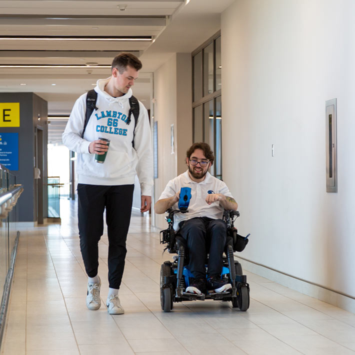 Two students, one walking and the other in a wheelchair.