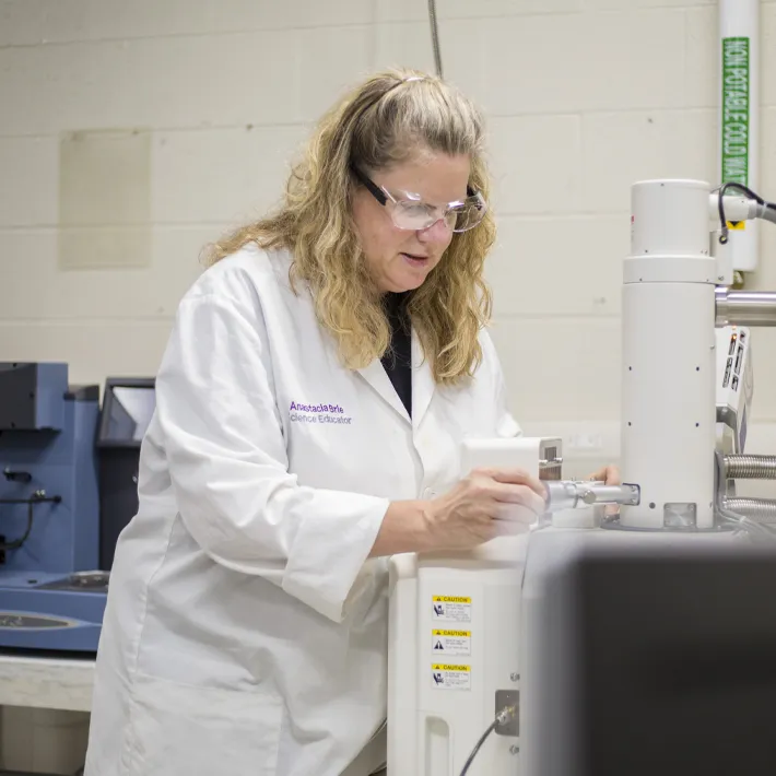 Student in lab testing and researching.