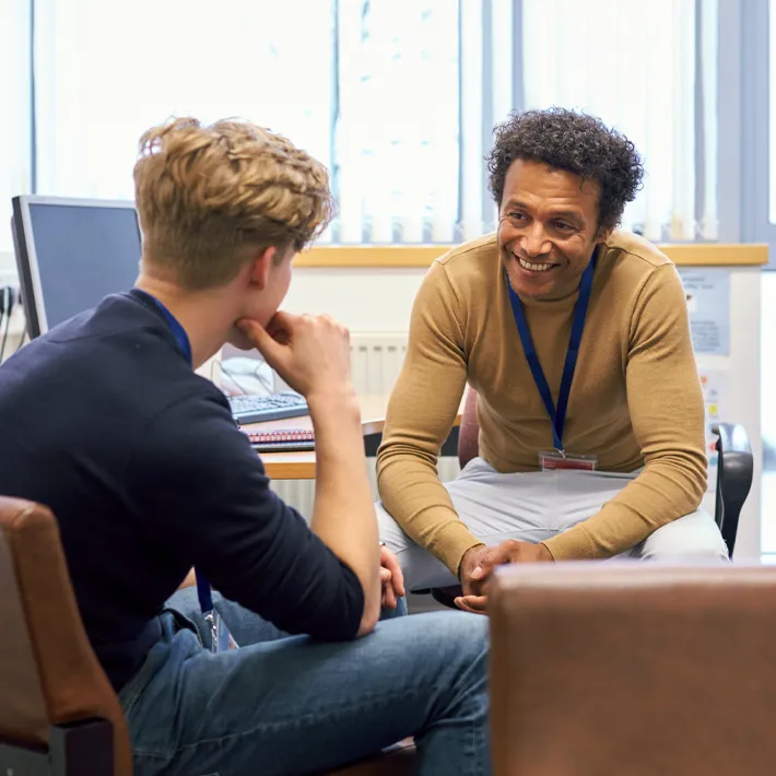 teacher-student-provider-support A students sits with teach in a private office to discuss support services.