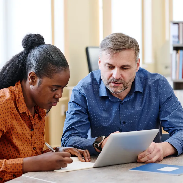 teacher-student-working-help-support A teacher helping a student with college work support.