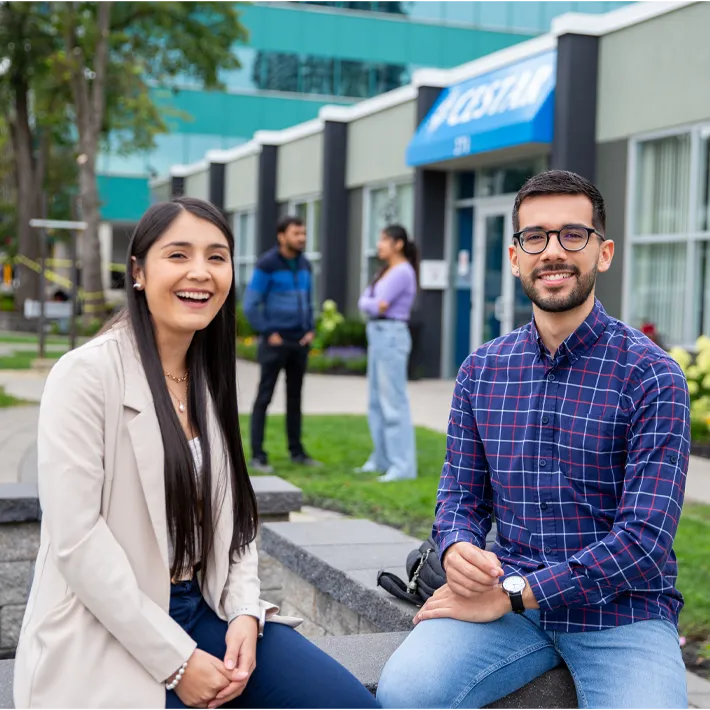 Cestar-Lifestyles-international-students Two international students (man and woman) sitting outside smiling for photo.