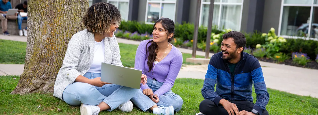 cestar-lifestyles-students-international Students sitting outside on campus grounds laughing and smiling.