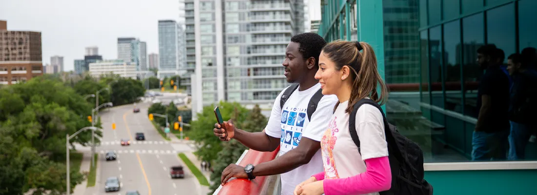 Cestar-Lifestyles-toronto-international A photo of two students on the campus balcony area overlooking the city of Toronto.