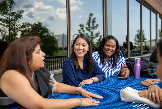 Students sitting at a bench outside.