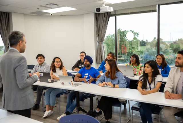 International students in a classroom setting with teacher.