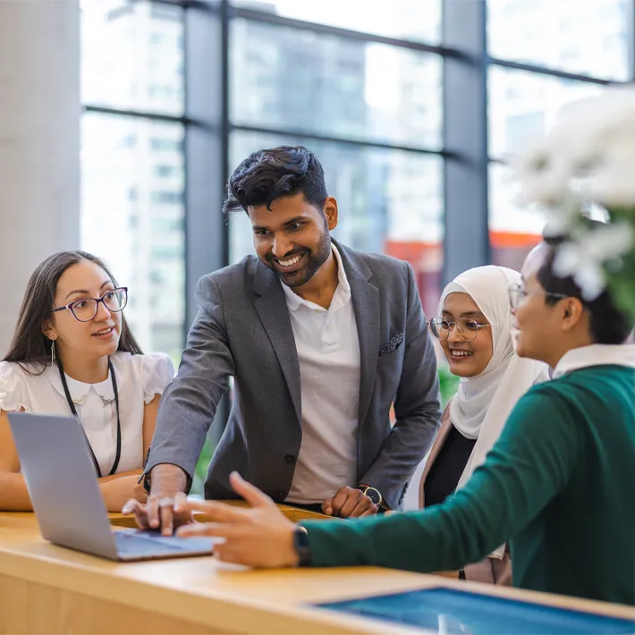 A group on international students interacting with each other at table.