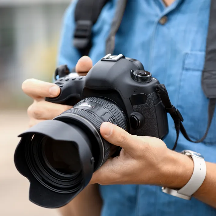 international-students-photo-club A close-up image of an international student holding a digital camera.