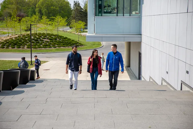 Students on campus outside walking up steps.