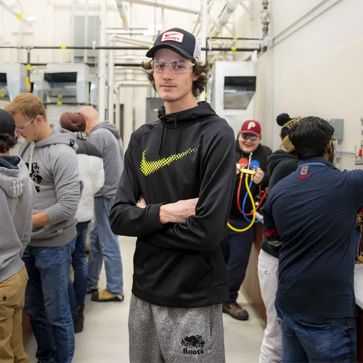 A student standing in lab area with other students.