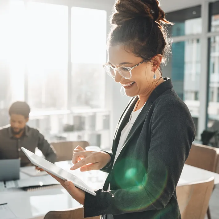 Business woman in office holding ipad.