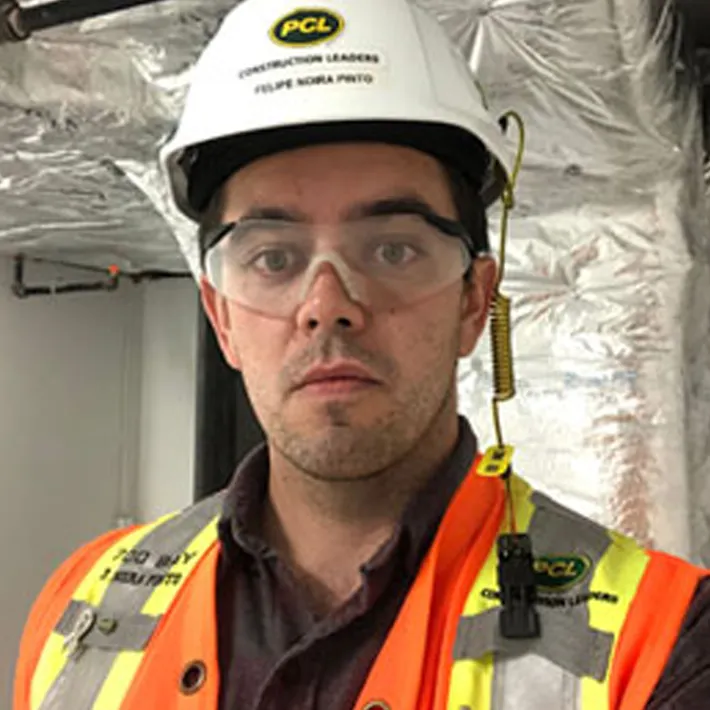 A photo of a student graduat, Felipe Noira Pinto, wearing on-site protective gear.