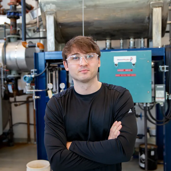 Student posing for photo in boiler room.