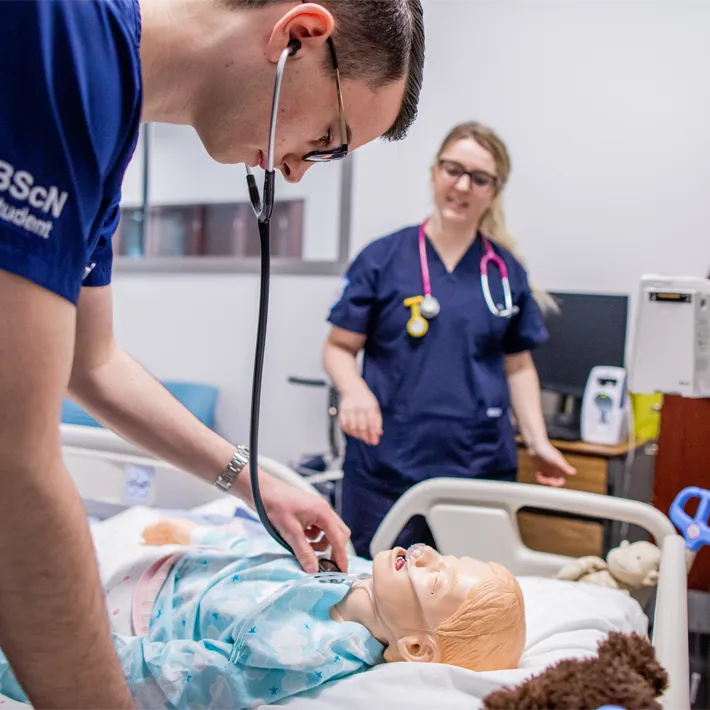 Nursing students practising on a mannequin. 