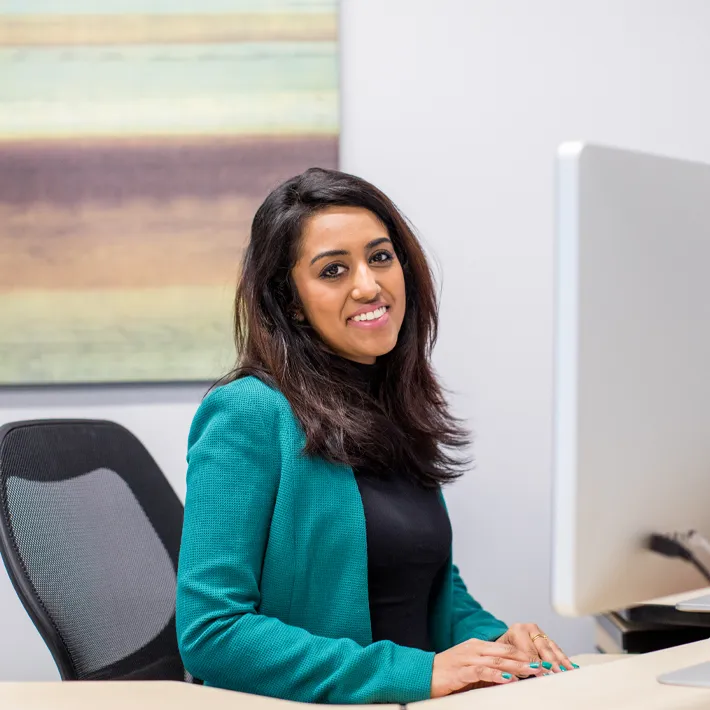 Student sitting at computer smiling for photo.