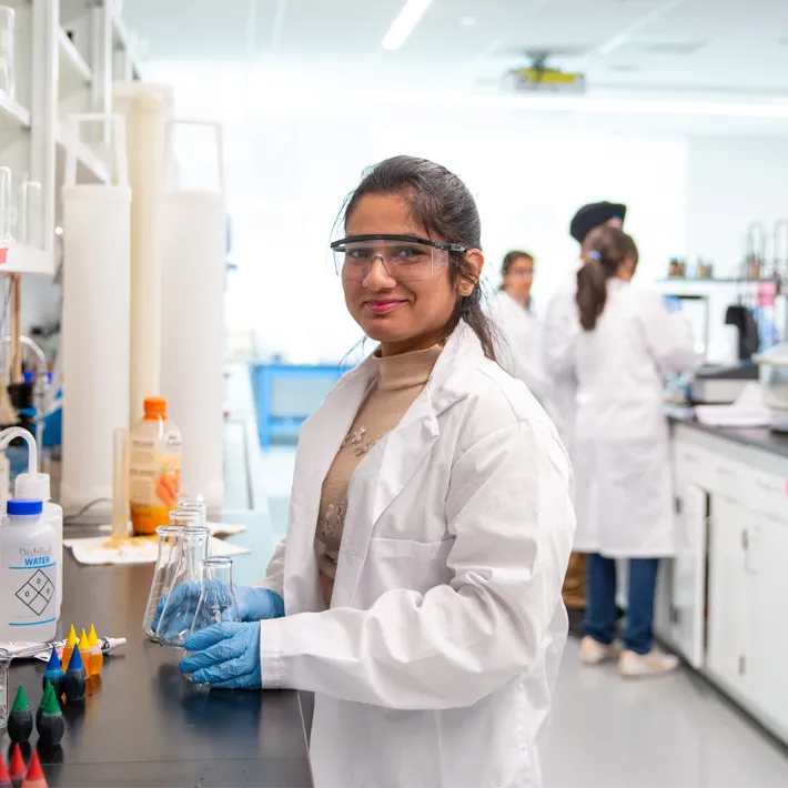 Student smiling in chemistry lab.