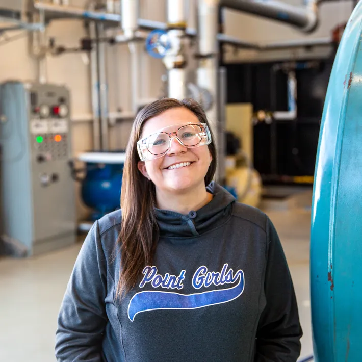 Student standing in boiler room posing for photo.