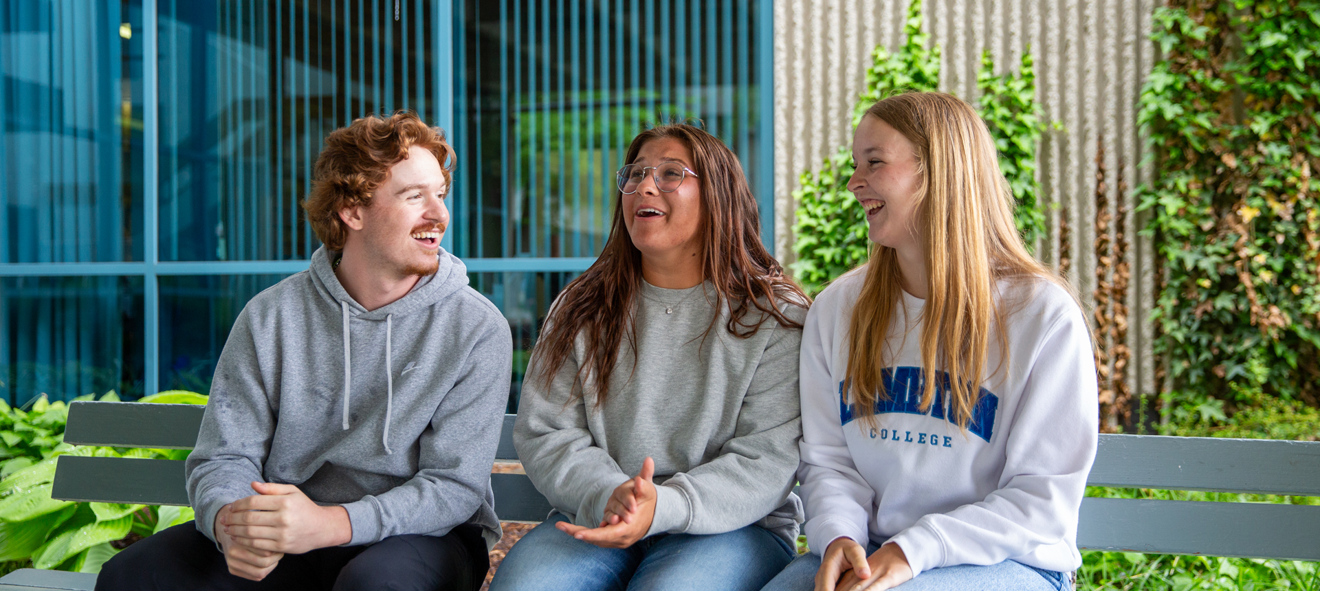 Students chatting on a bench outside lambton college