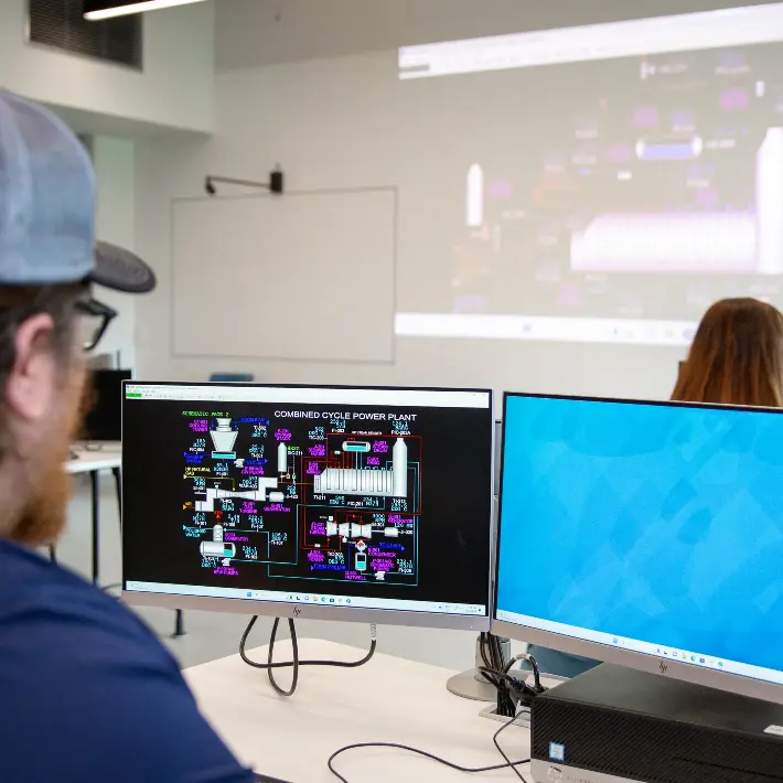 A student in a computer lab working on a piping drawing
