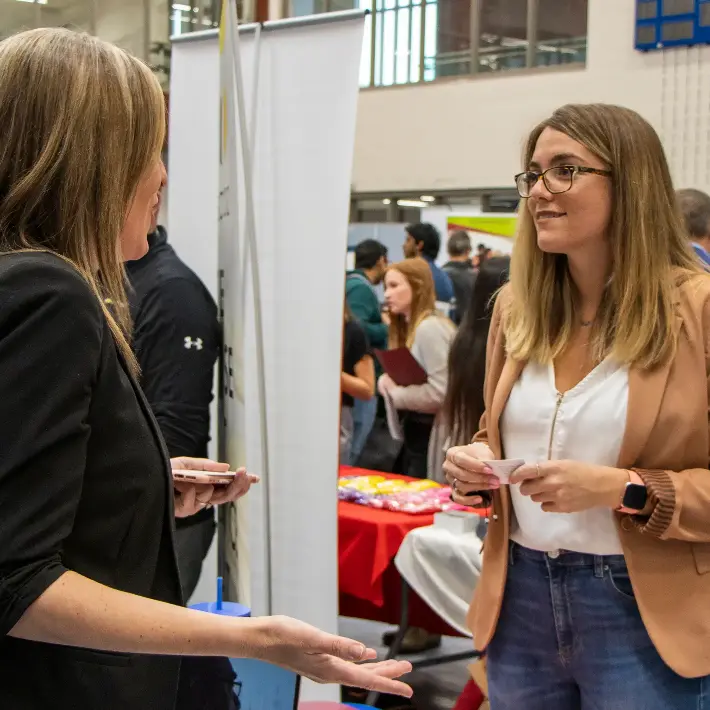 A student talking with a prospective employer at a Job Fair