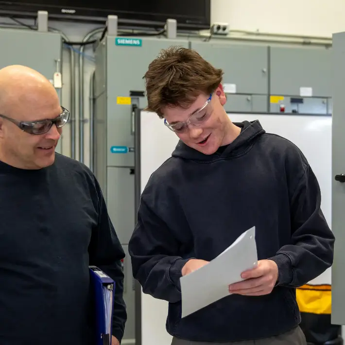 A faculty member instructing a student in an electrical lab