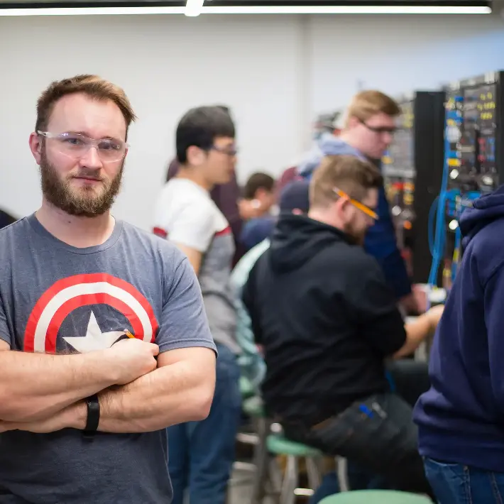 Student standing in electrical lab with arms crossed