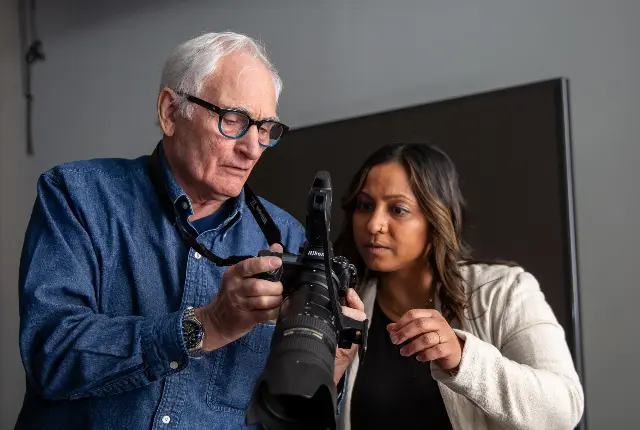 A faculty member assisting students with photography