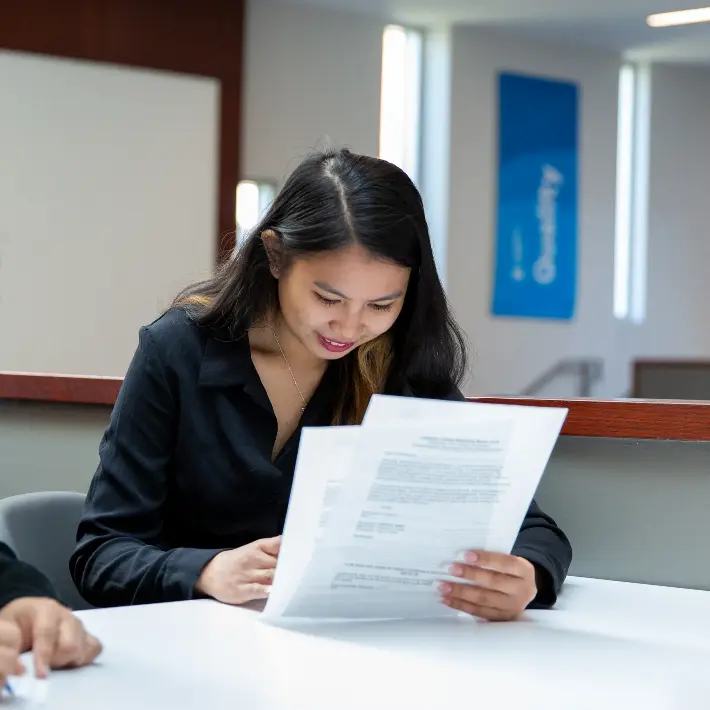Two students working together a table writing