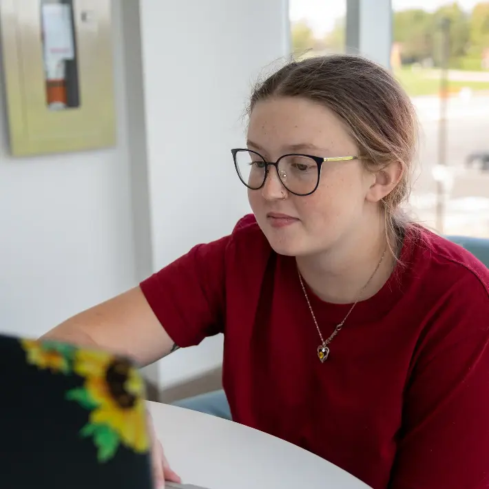 A woman working at her laptop in a student workspace