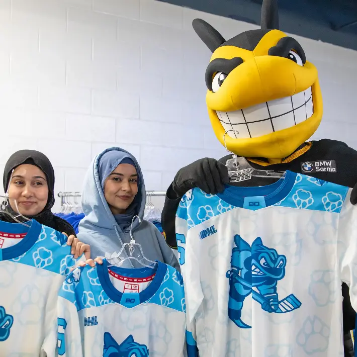 A group of students pose with Pounce at Lion's Night at the Sting arena