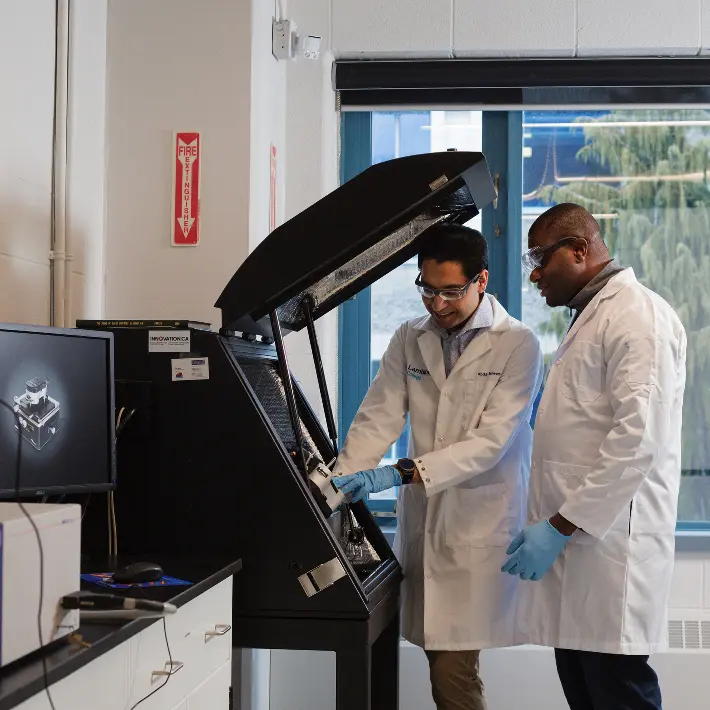 Two students are in the research lab doing tests.
