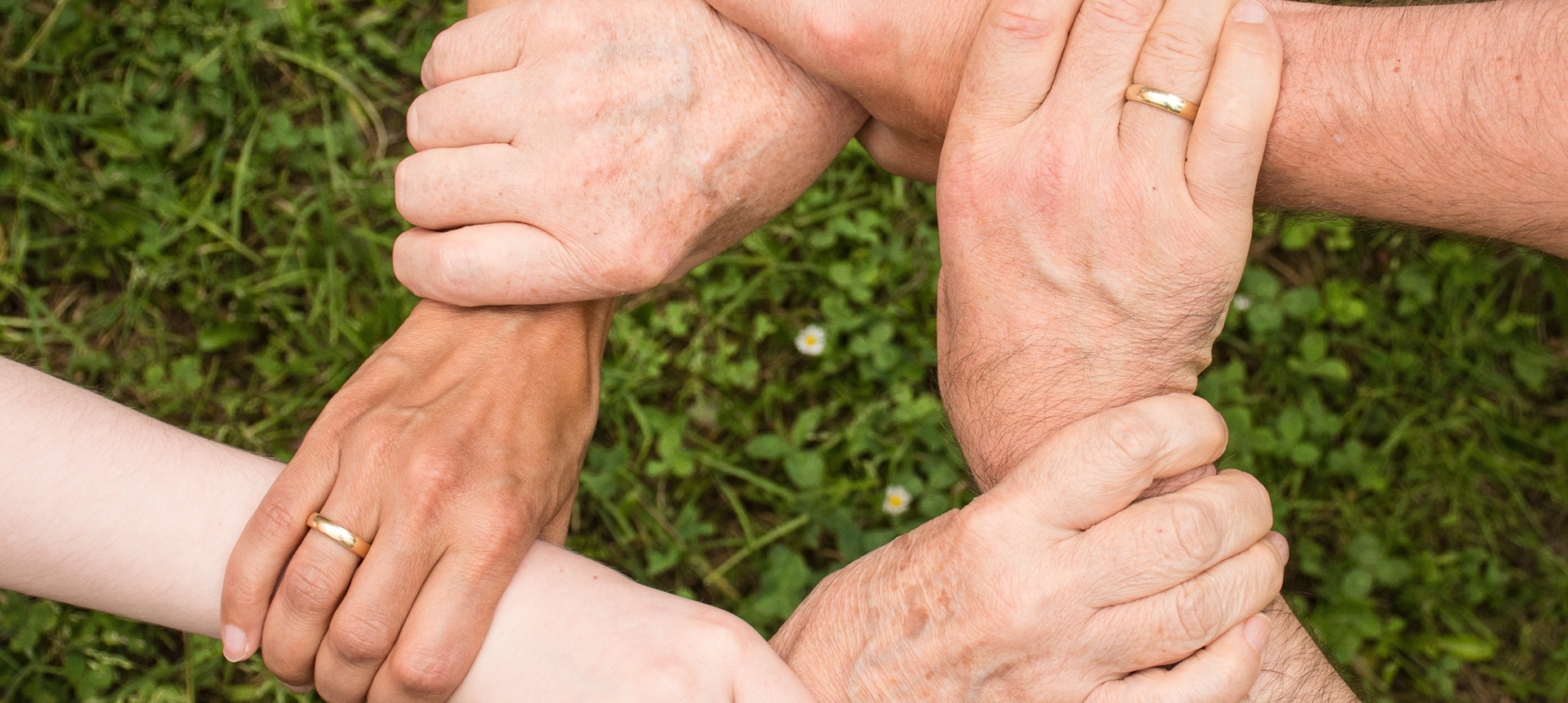 Five people joining hands at the wrist