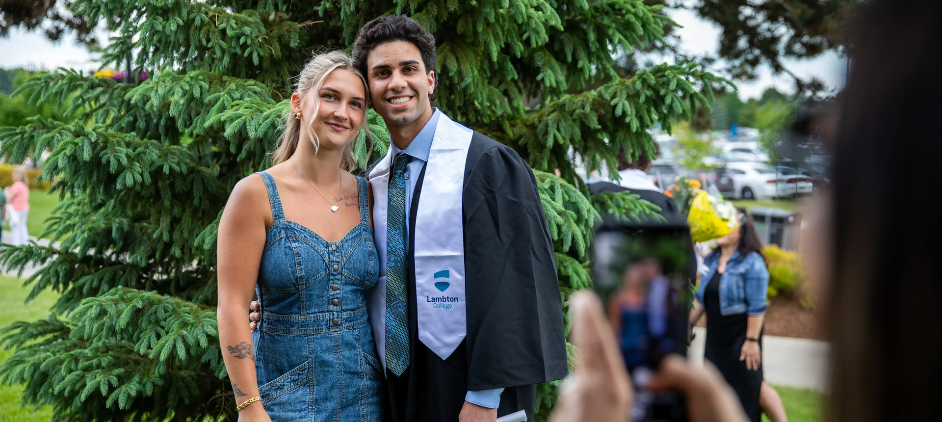 Two students smiling for a selfie at Convocation 2025