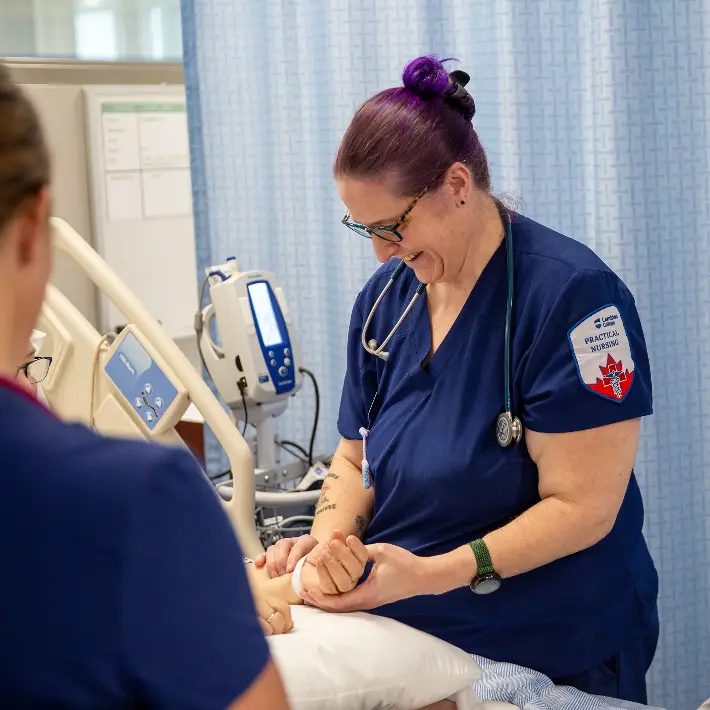Student checking pulse in Nursing Lab