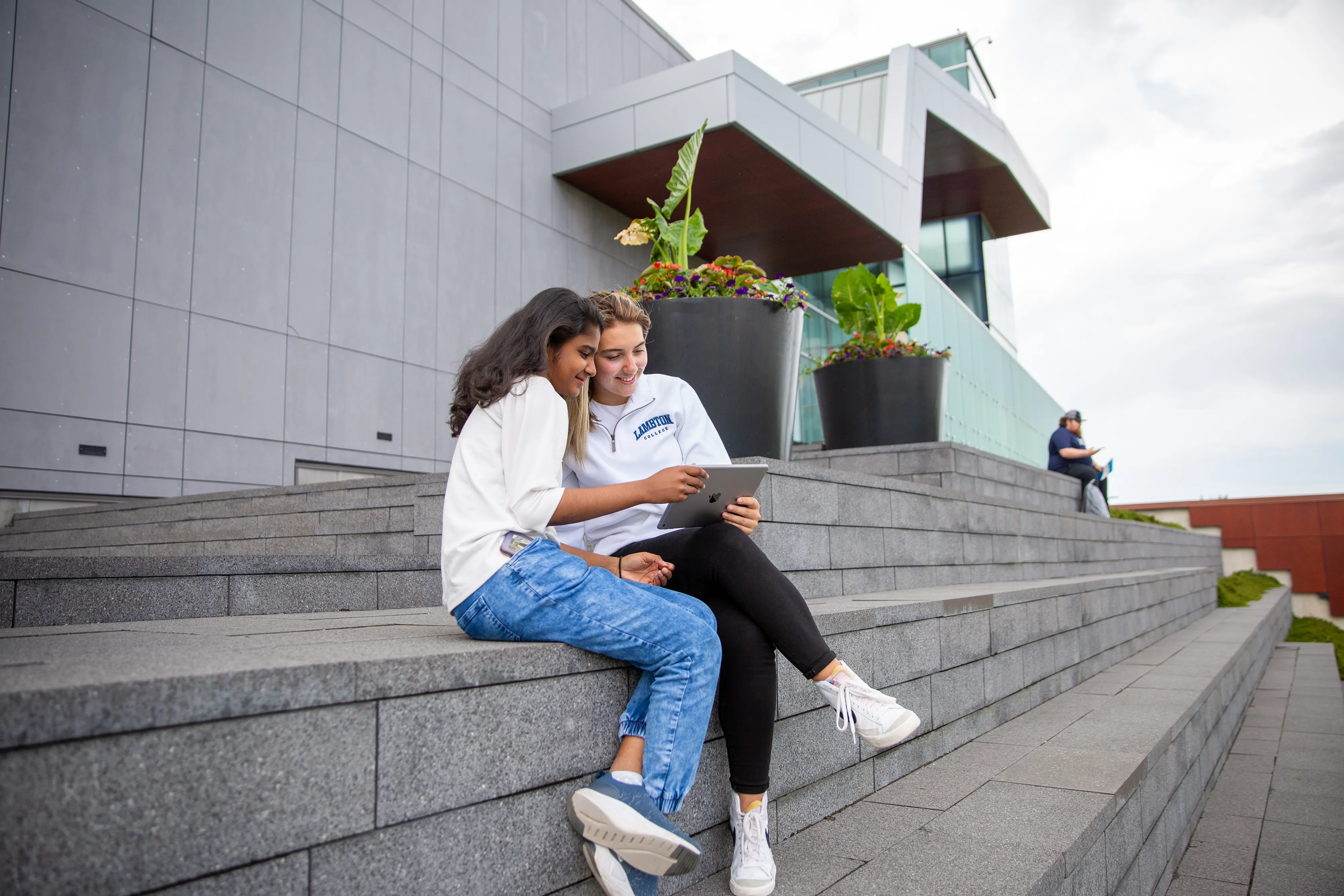 Two students sitting outdoors on the steps