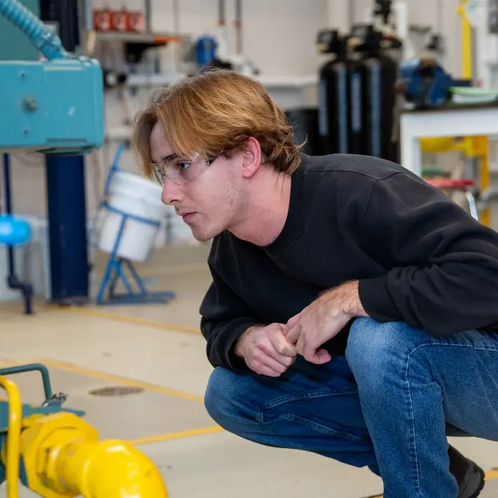 A technology student observing in a boiler lab