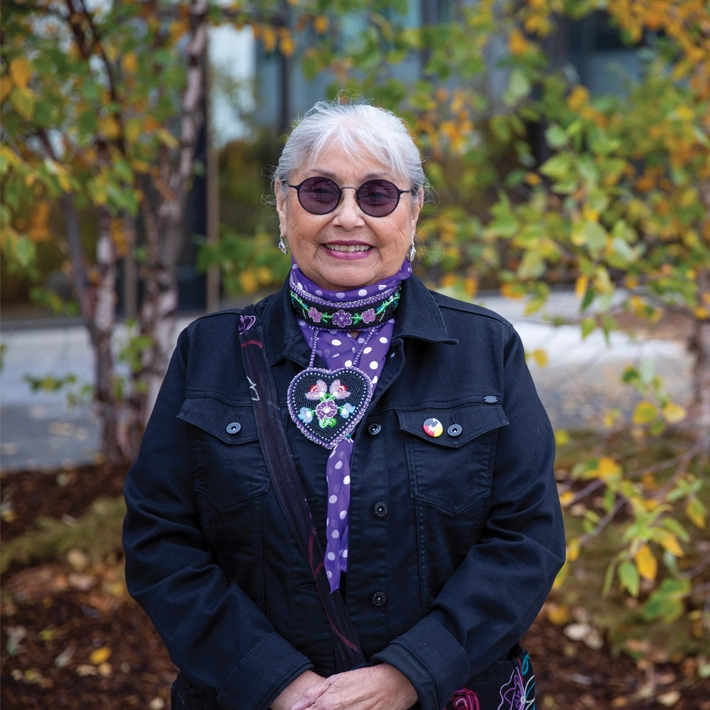 A photo of indigenous elder posing outside of Lambton College.